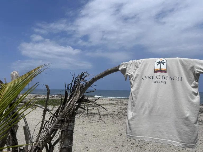 A Mystic Beach Resort t-shirt hung over an archway made of driftwood